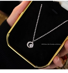 Macro shot of S999 sterling silver moon pendant with sparkling cubic zirconia on black velvet