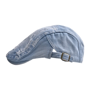 Close-up of light blue distressed denim ivy cap featuring side adjustable bronze buckle