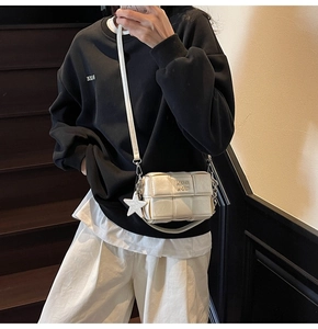 Détail du sac bandoulière carré tissé blanc cassé avec pendentif en forme d'étoile
