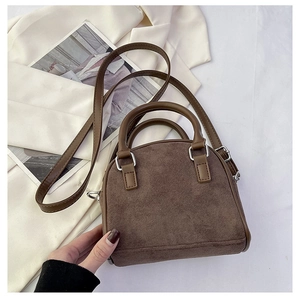 Brown vintage suede handbag with top handles and shoulder strap in an aesthetic layout