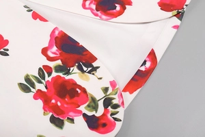 Gros plan du motif floral rose rouge sur tissu blanc avec bordure et couture soignées
