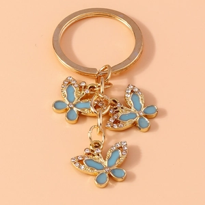 Detail of golden butterfly keychain with light blue enamel wings and sparkling rhinestones