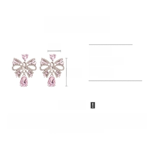 Vue détaillée des boucles d'oreilles nœud rose montrant les dimensions et le poids