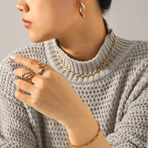 Model wearing two-tone gold and silver necklace, bracelet, earrings and ring set