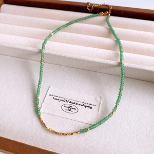 Detail of beaded necklace with green aventurine stones and 18K gold plated accents