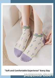 Detailed view of jacquard floral pattern and green ruffle cuff on purple cotton socks