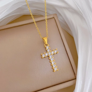 Detailed close-up of golden titanium steel cross necklace with sparkling zircon stones