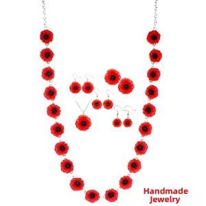 Détails d'un ensemble de colliers et boucles d'oreilles coquelicot rouge sur fond blanc