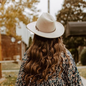Classic cream wool fedora hat with a thin buckle band shown in an outdoor back view