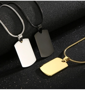 Polished stainless steel ID tags in silver, black and gold finishes on textured background