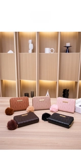 Detailed view of quilted PU leather mini wallets with gold trim and plush pompoms