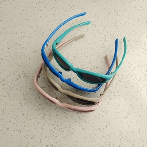 Top view of colorful kids polarized sunglasses in pink blue and khaki on stone surface