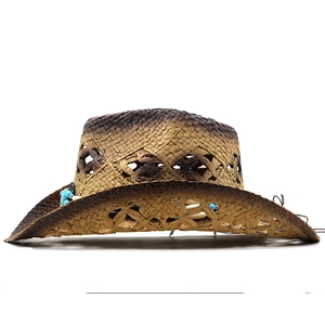 Detail of hollow floral pattern and ethnic beads on brown gradient straw cowboy hat