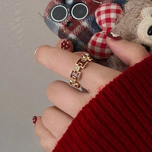 Gold-plated H-letter link ring with red enamel and pavé zircons worn on finger
