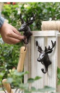 Close-up of vintage cast iron deer head wall hook with rustic bronze finish for home decor