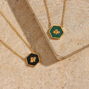 Detail view of pentagonal bee pendants with black and green malachite marble inlays