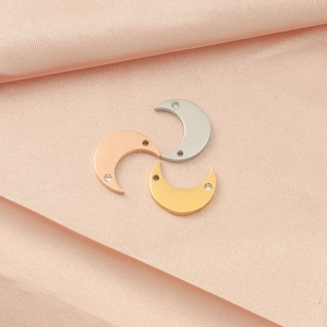 Detailed view of crescent moon pendants with crystal accents in gold, silver, and rose gold