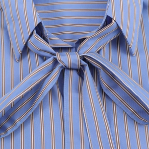Detalle del escote de la camisa de rayas con un elegante diseño de lazo decorativo