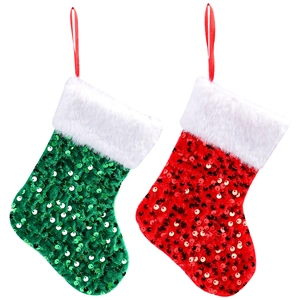 Red and green sequined Christmas stockings with white plush cuffs on white background