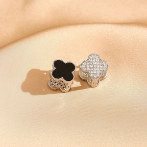 Detail of clover earrings with black enamel and zircon pavé on champagne satin silk
