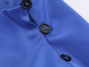 Makroaufnahme der blauen Twill-Stoffstruktur und drei schwarzen Knöpfen am Hemd