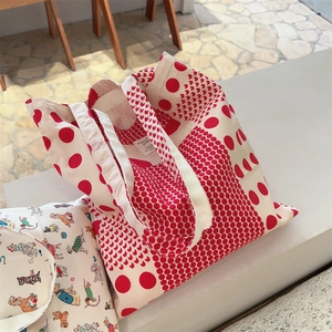 Detailed close-up of red polka dot and puppy print cotton canvas tote bags