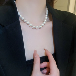 Close-up of elegant pearl and textured silver bead necklace worn on model's neck