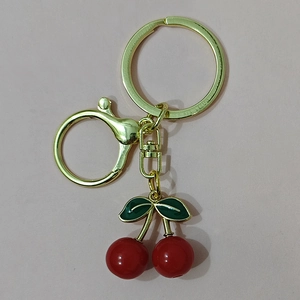 Red crystal resin cherry keychain with green enamel leaves and golden metal lobster clasp