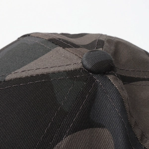 Detailed close-up of cotton camouflage baseball cap top button and precision stitching