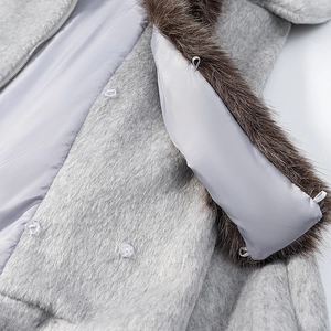Détail du manteau en laine pelucheuse grise avec col en fausse fourrure brune et bouton