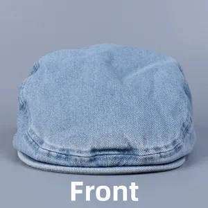 Front view of a light blue washed denim flat cap with classic twill texture