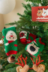 Gros plan de chaussettes de Noël en polaire corail suspendues au sapin festif