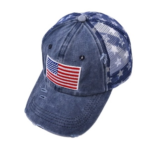 Detailed close-up of distressed denim baseball cap with American flag patch and stars