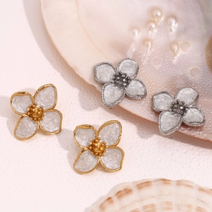 Close-up of flower stud earrings with pearlescent enamel petals in gold and silver frames