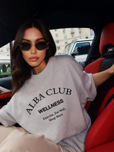 Oversized γκρι βαμβακερό T-shirt με τύπωμα Alba Club Wellness σε εσωτερικό πολυτελούς αυτοκινήτου