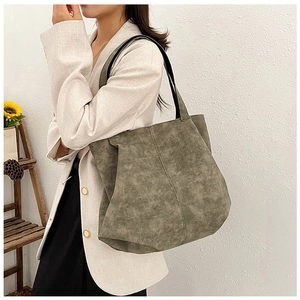 Detail view of large olive green tote bag in matte texture with black shoulder strap