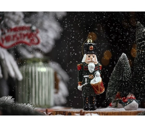 Detail of Nutcracker ornament with drum on a festive background for Christmas tree decor