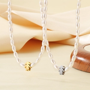 Macro shot of double-layer beaded necklaces featuring white pearls and girl pendants