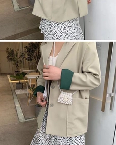 Detail of a handmade mini white pearl woven crossbody bag styled with a beige blazer