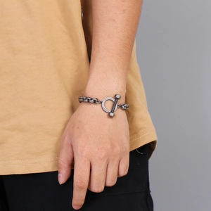 Détail d'un bracelet double chaîne industriel gunmetal avec fermoir à barre texturée