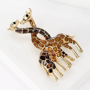 Detail of interlocking twin giraffes brooch with brown enamel spots and gold finish