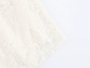 Close-up of elegant cream white lace fabric with delicate floral knit patterns