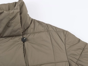 Detail of high stand collar and quilted pattern on dark khaki winter jacket with button