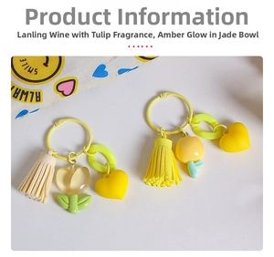 Detail view of yellow resin tulip keychain with tassel and heart charm on white desk