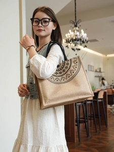 Detailed view of large jute tote bag with black mandala pattern and woven handles