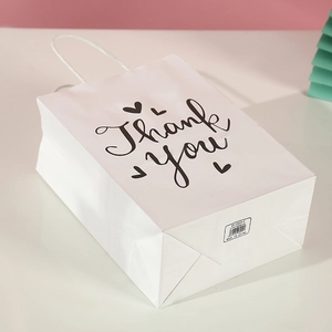 Detailed view of white Thank You gift bag showing size labels and kraft paper texture
