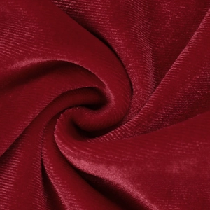 Detailopname van wijnrode fluwelen stof met gladde textuur en zachte drapering
