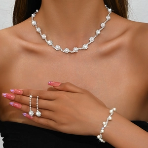 Elegant bridal jewelry set with silver rhinestones and pearls worn by a model