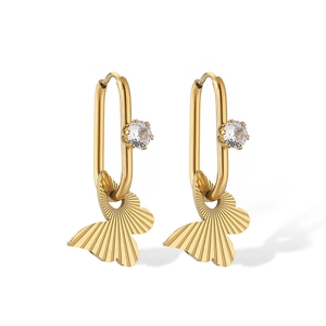 Detail of gold butterfly pendant on oval hoop earring with a sparkling cubic zirconia stone