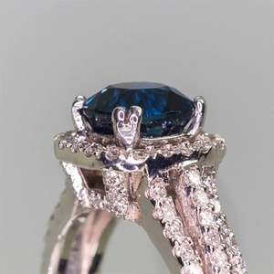 Luxury copper ring featuring a deep blue zircon halo and triple row micro-pave shank